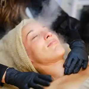 Client relaxing during a facial steam session